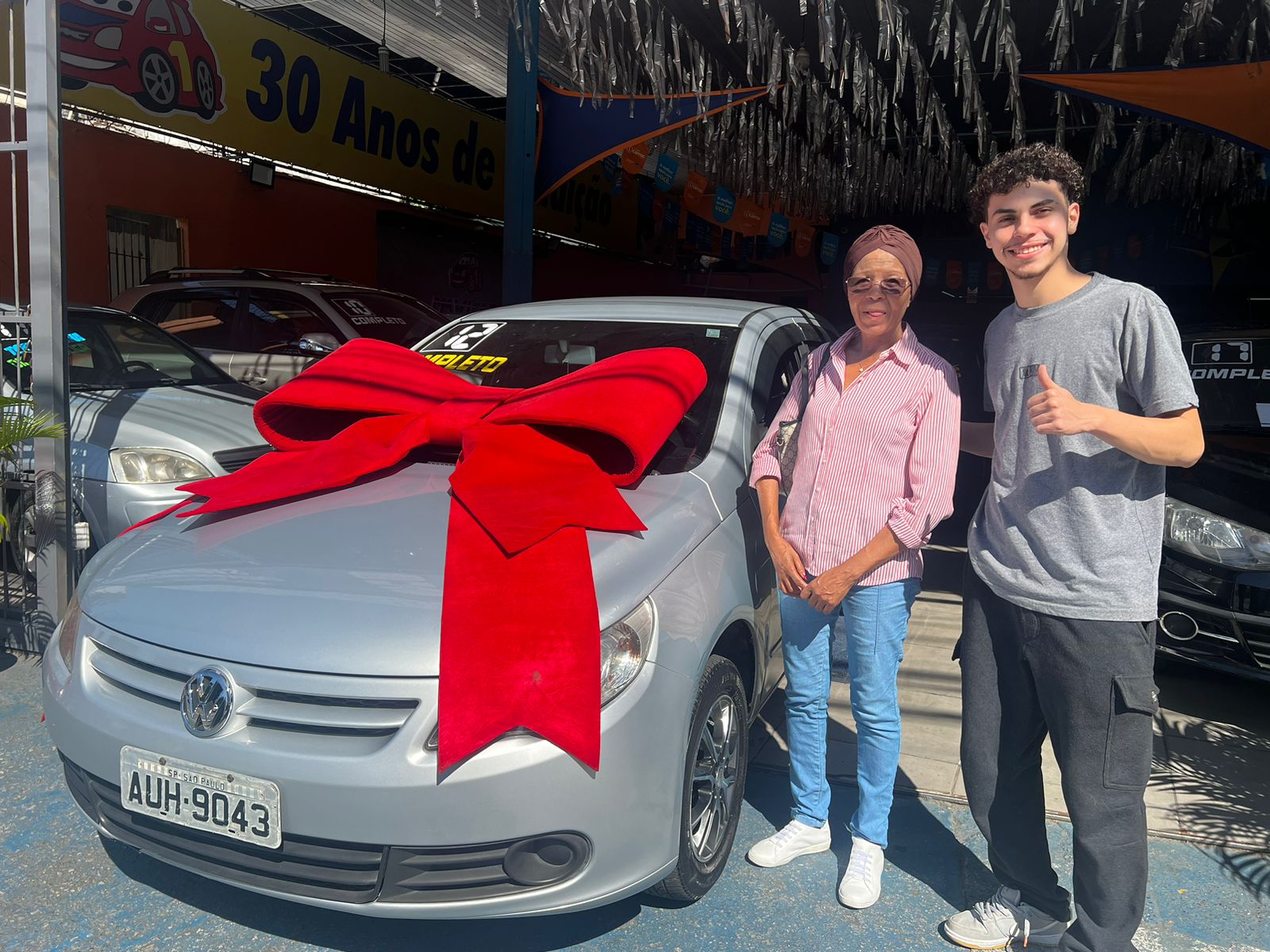Cliente recebendo seu carro com laço vermelho
